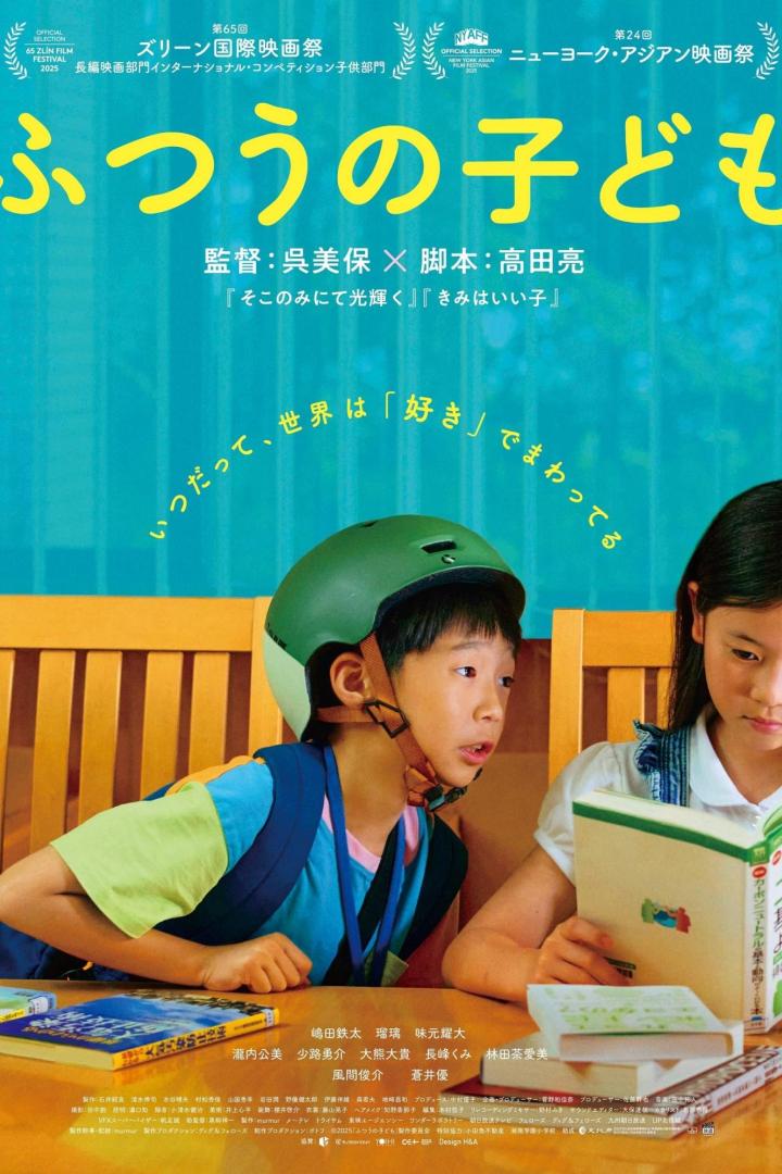 Ein Junge mit Fahrradhelm liest mit einem Mädchen zusammen in einem Buch.