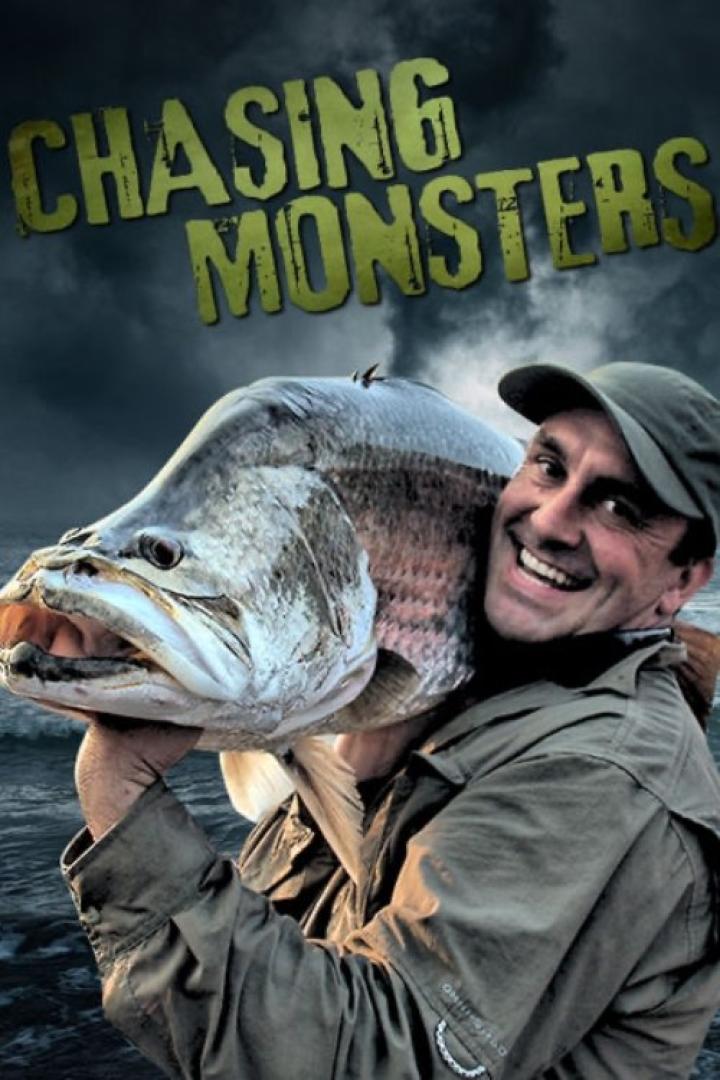 Ein Mann trägt einen riesigen Fisch vor dem Hintergrund des Titels „Chasing Monsters“.