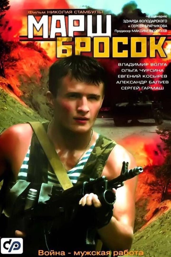 Ein Soldat mit einer Waffe vor einem brennenden Hintergrund, vermutlich eine Szene aus dem Film „Marsch-Brosok“.