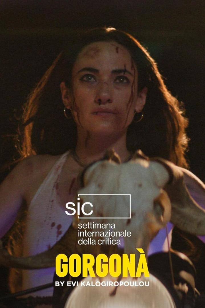 Eine verletzte Frau hält einen Tierkopf in der Hand, im Hintergrund das Filmplakat „Gorgonà“.