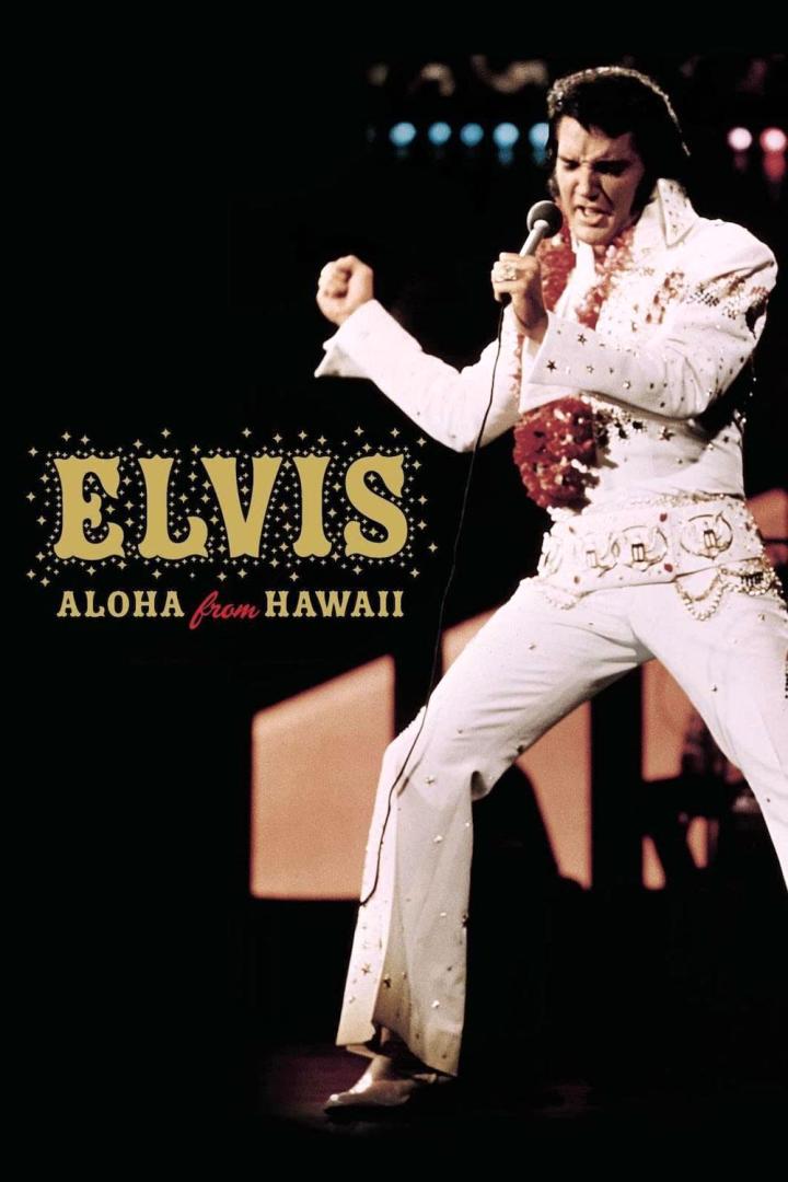 Elvis Presley tritt in seinem weißen „Aloha from Hawaii“-Anzug auf einer Bühne auf.