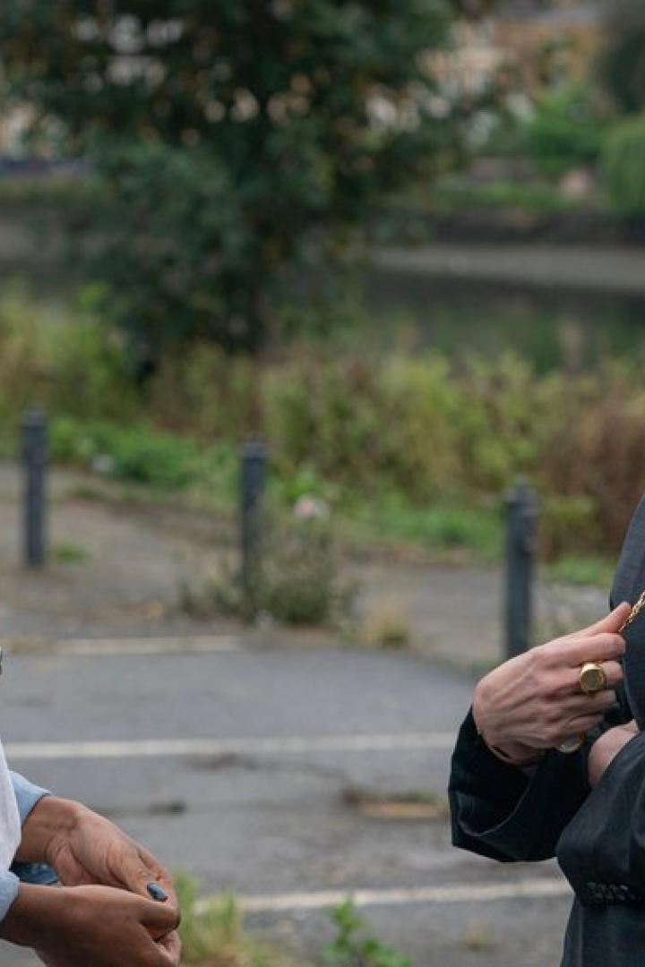 Zwei Frauen stehen einander auf einem Parkplatz gegenüber