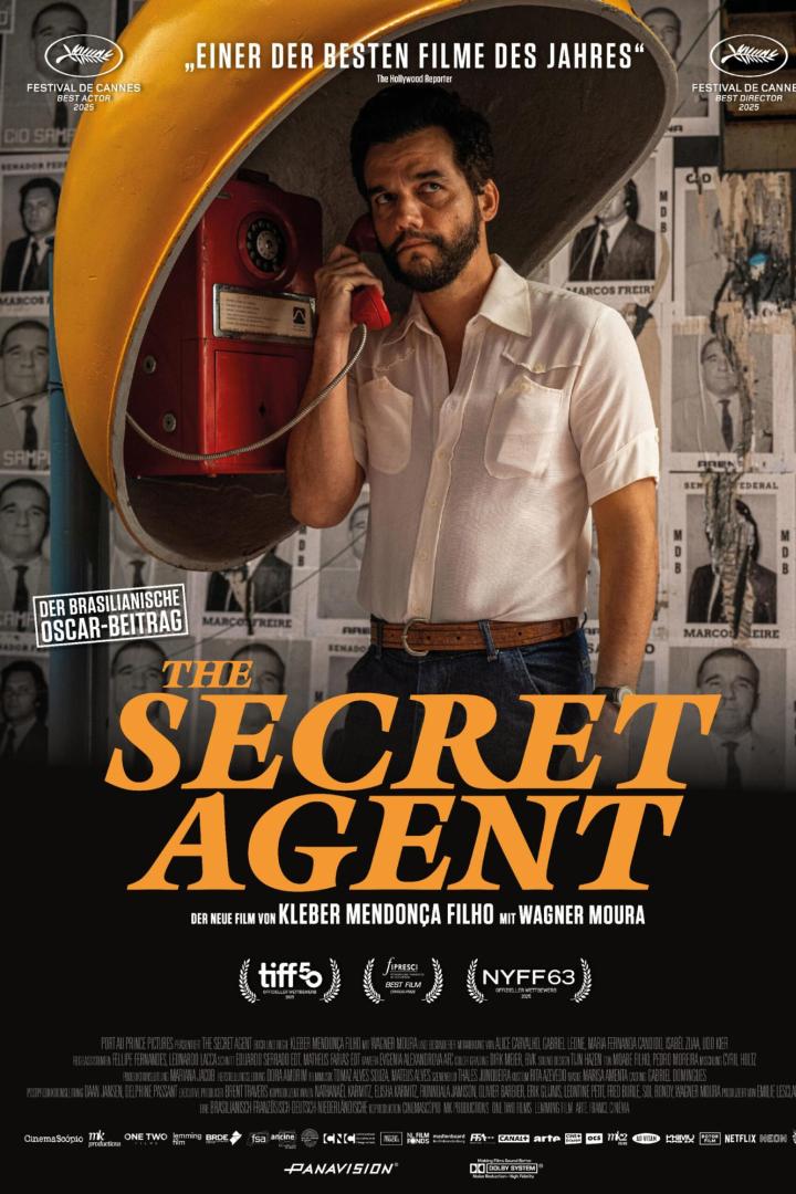 Mann telefoniert mit öffentlichem Telefon, während an der Wand im Hintergrund Fahnungsplakat zu sehen sind