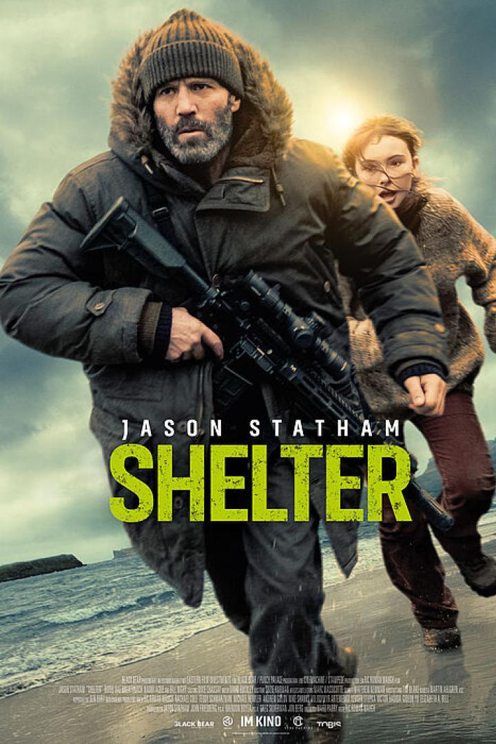 Jason Statham läuft mit einer Waffe in der Hand vor einem Mädchen über einen Strand