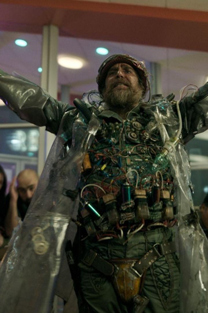 Sam Rockwell trägt in der Filmrolle einen Sprengstoffgürtel und steht mit ausgebreiteten Armen da