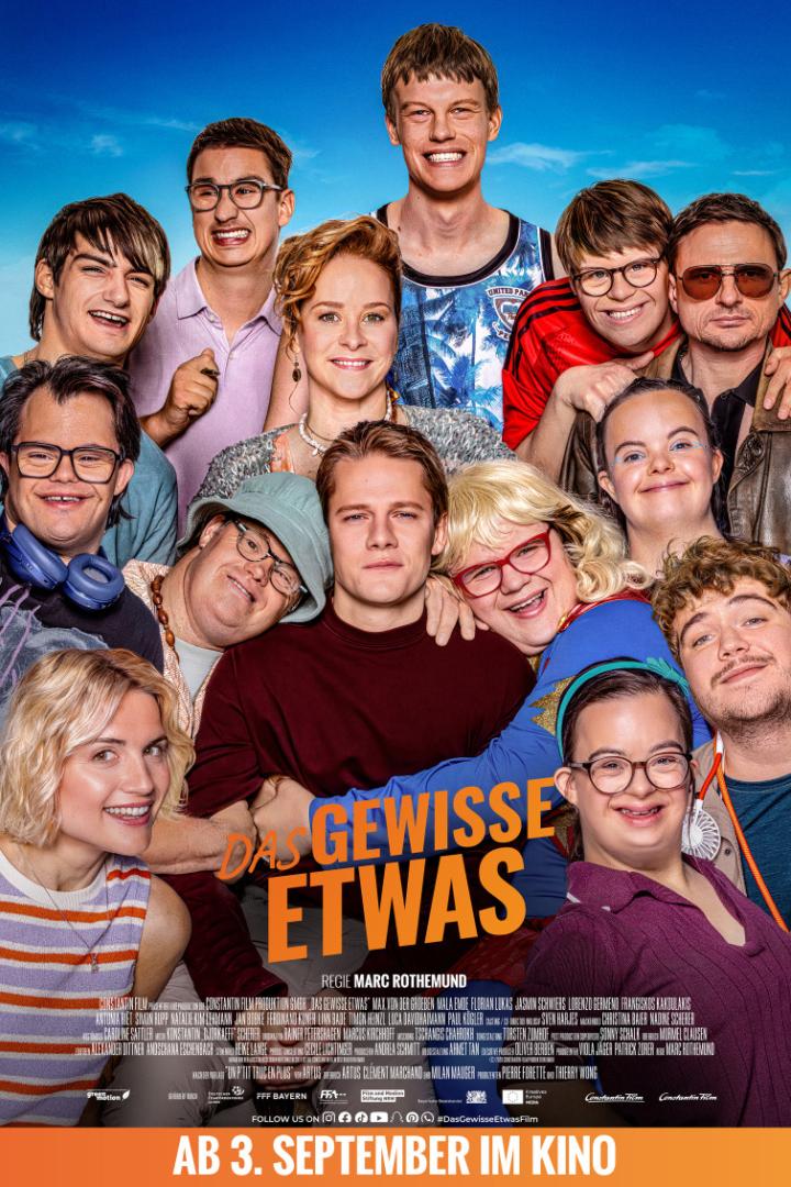 Eine diverse Gruppe von Menschen lächelt gemeinsam auf dem Filmplakat zu „Das gewisse Etwas“ unter der Regie von Marc Rothemund.