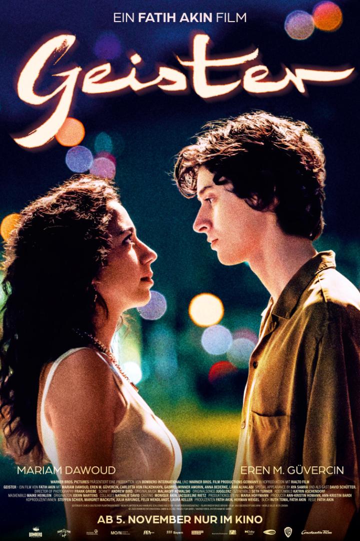 Filmplakat von „Geister“ mit zwei einander gegenüberstehenden jungen Menschen vor unscharfen Lichtern.