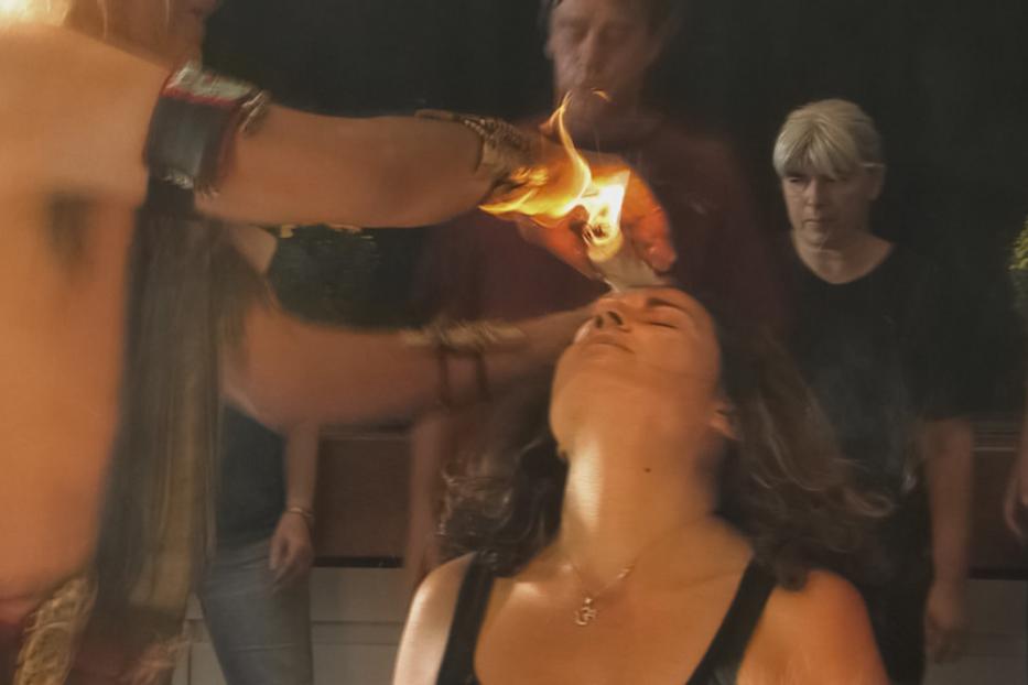 Eine Frau erhält eine Feuerheilung auf ihrer Stirn.