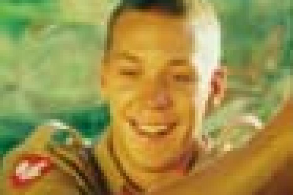 Ein junger Mann in Uniform lächelt in die Kamera.