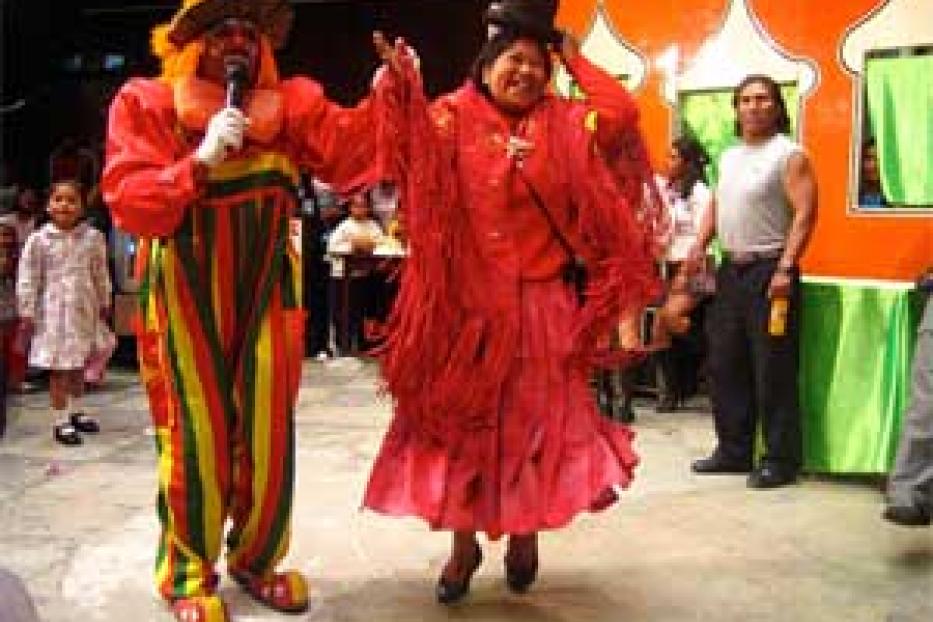 Zwei als Clowns verkleidete Personen treten vor einem Publikum auf.