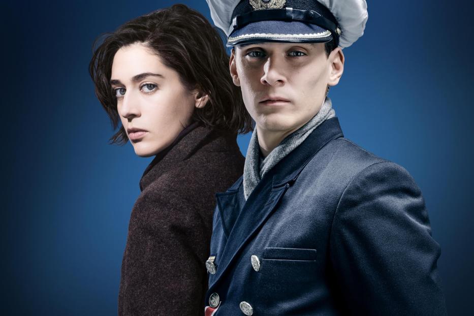 Ein Mann in Marineuniform und eine Frau vor einem dunkelblauen Hintergrund, mit dem Titel „Das Boot“.