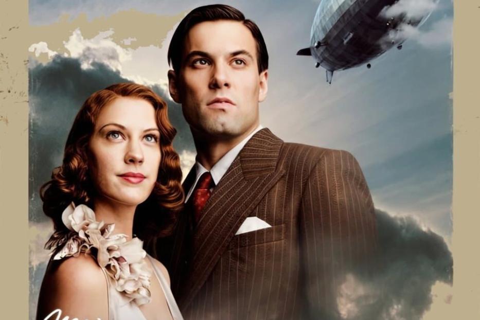 Ein Filmposter für „Hindenburg“ mit einem Paar und einem Luftschiff im Hintergrund.