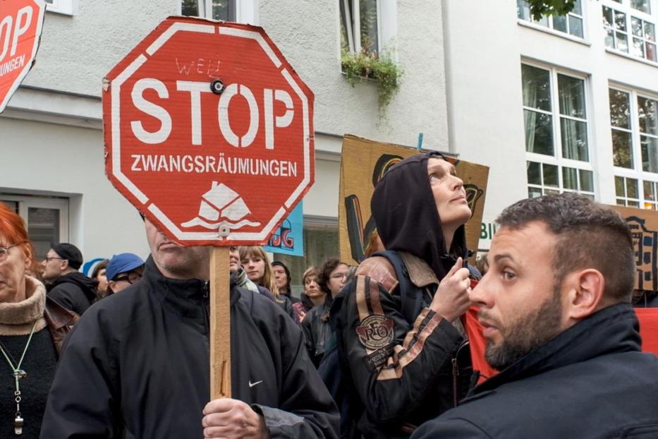 Menschen demonstrieren mit Schildern gegen Zwangsräumungen.