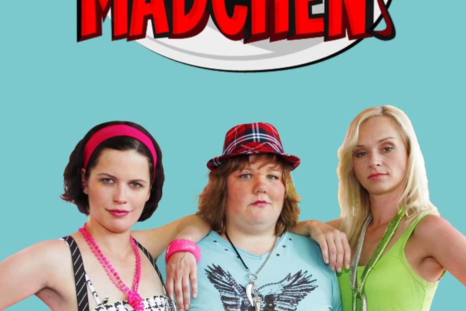 Drei Frauen posieren vor dem Schriftzug „Böse Mädchen“.