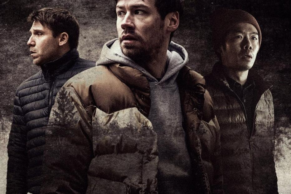 Das Filmplakat für „Prey“ zeigt drei Männer in Winterkleidung vor dunklem Hintergrund.