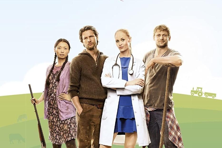 Das DVD-Cover der ersten Staffel von „Doc meets Dorf“ zeigt vier Hauptdarsteller vor ländlicher Kulisse.