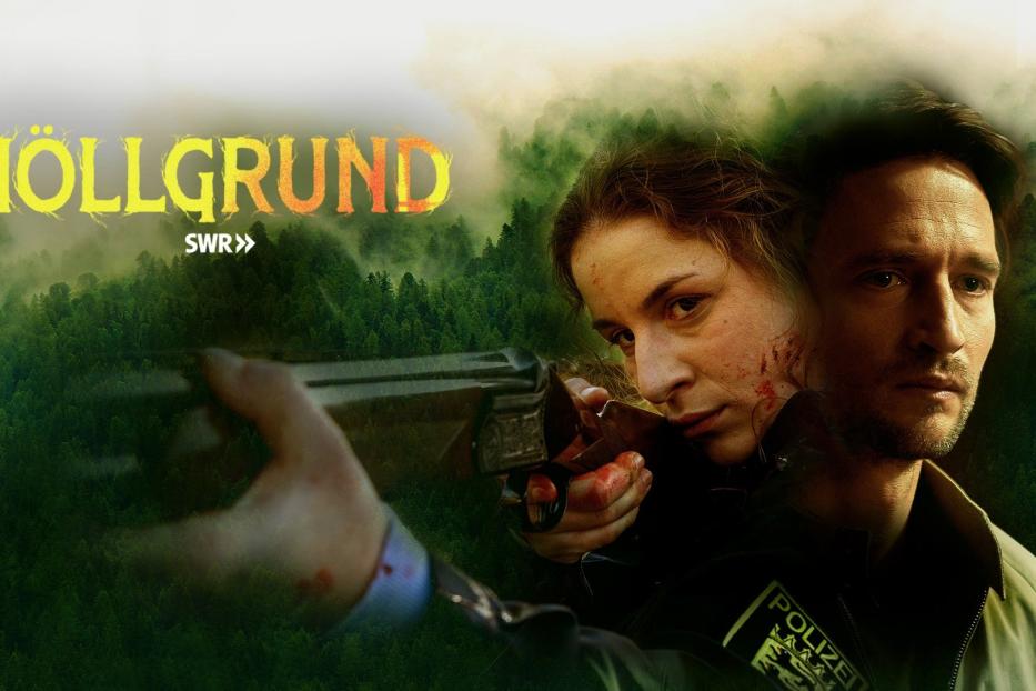 Eine Polizistin zielt mit einem Gewehr, während ein Mann neben ihr steht; im Hintergrund der Titel „Höllgrund“.