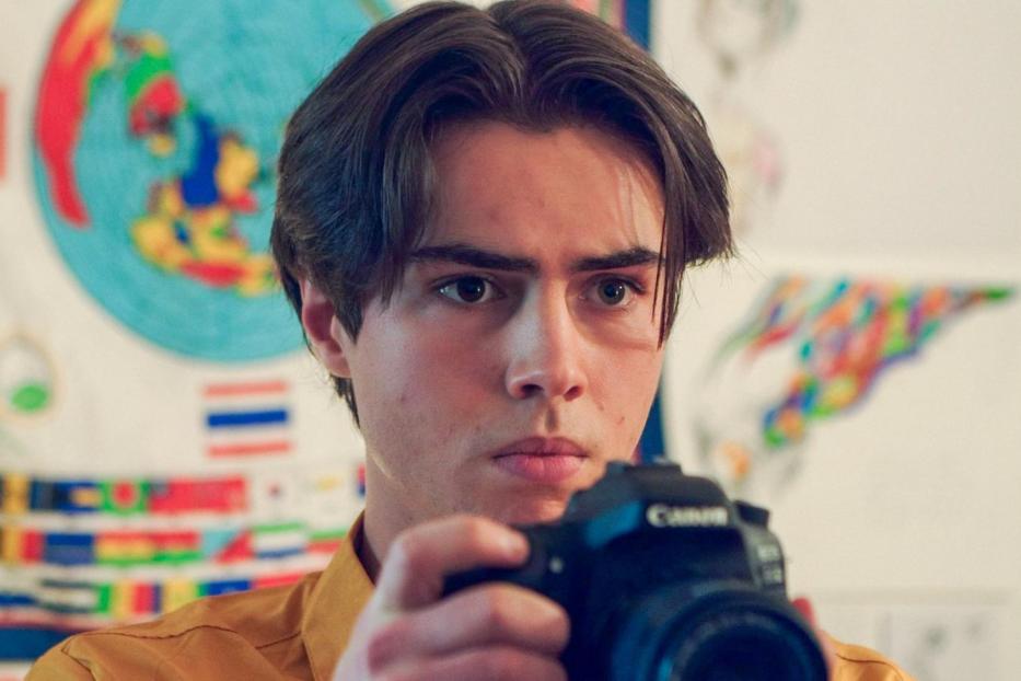 Ein junger Mann mit braunen Haaren fotografiert mit einer Canon-Kamera.