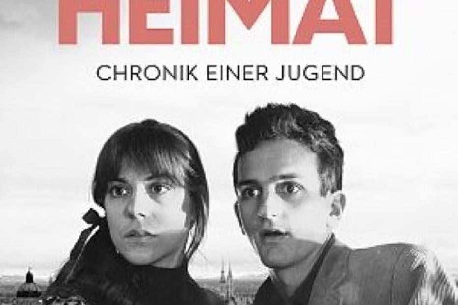Das Filmplakat für Edgar Reitz' „Die zweite Heimat – Chronik einer Jugend“ zeigt ein junges Paar vor einer Stadtkulisse.