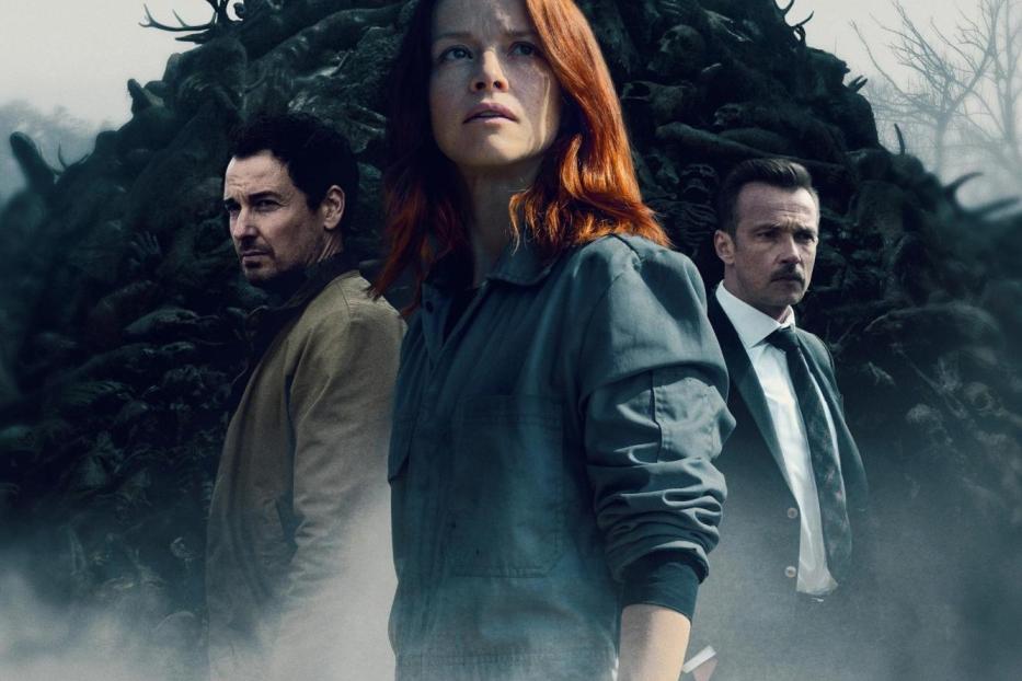 Das Filmplakat zu „Oderbruch“ zeigt eine Frau vor einem Berg aus Leichen und zwei Männer im Hintergrund.