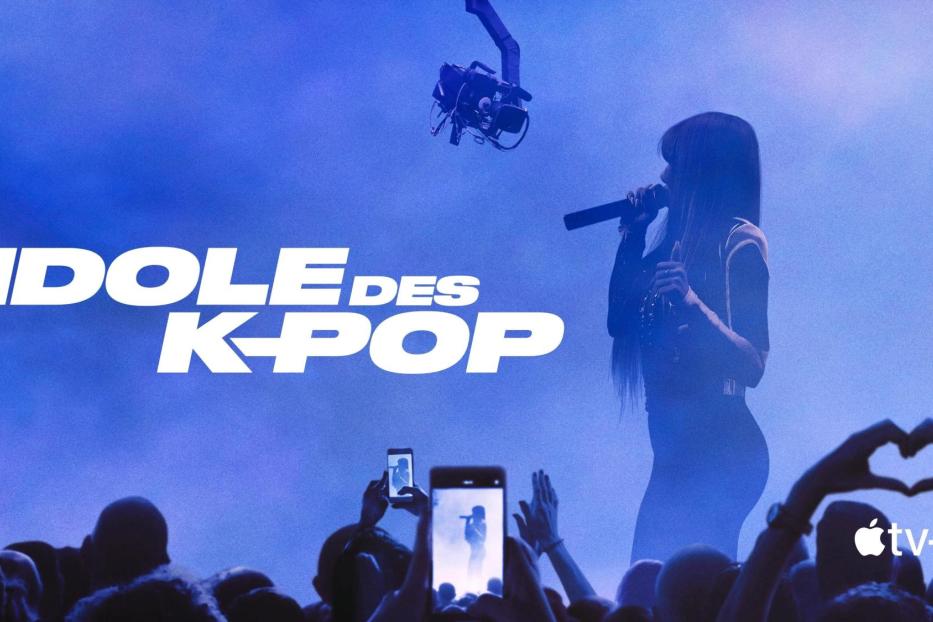 Eine K-Pop-Sängerin tritt vor einem Publikum auf, das Handys hochhält.