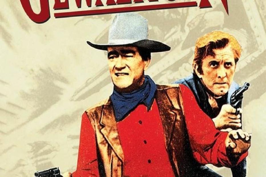 Das Filmplakat für „Die Gewaltigen“ zeigt John Wayne und Kirk Douglas mit Waffen.