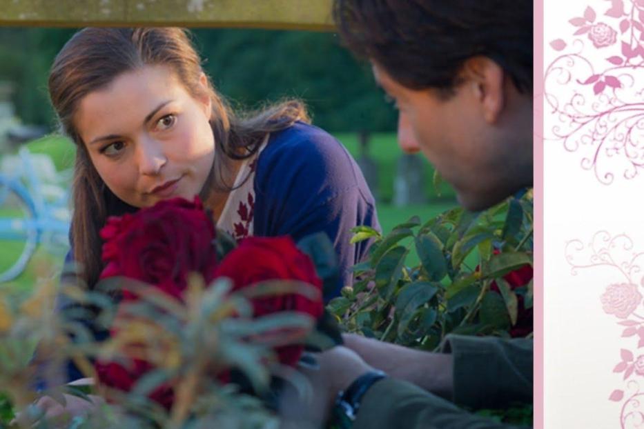 Das Cover des Rosamunde Pilcher Films „Besetzte Herzen“ zeigt eine Frau und einen Mann mit roten Rosen.