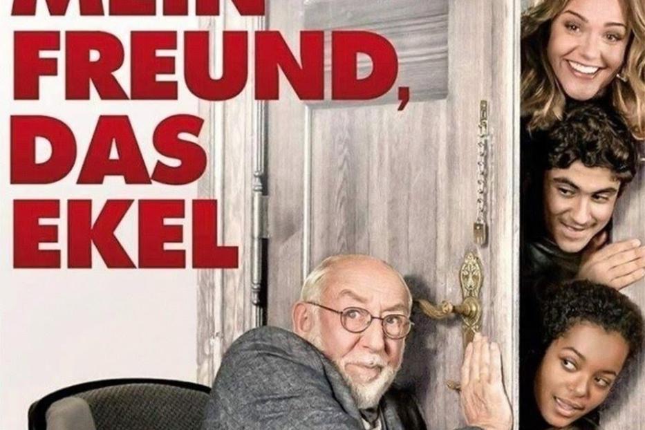 Das Filmplakat zu „Mein Freund, das Ekel“ zeigt einen älteren Mann im Rollstuhl und vier junge Leute, die durch eine Tür schauen.