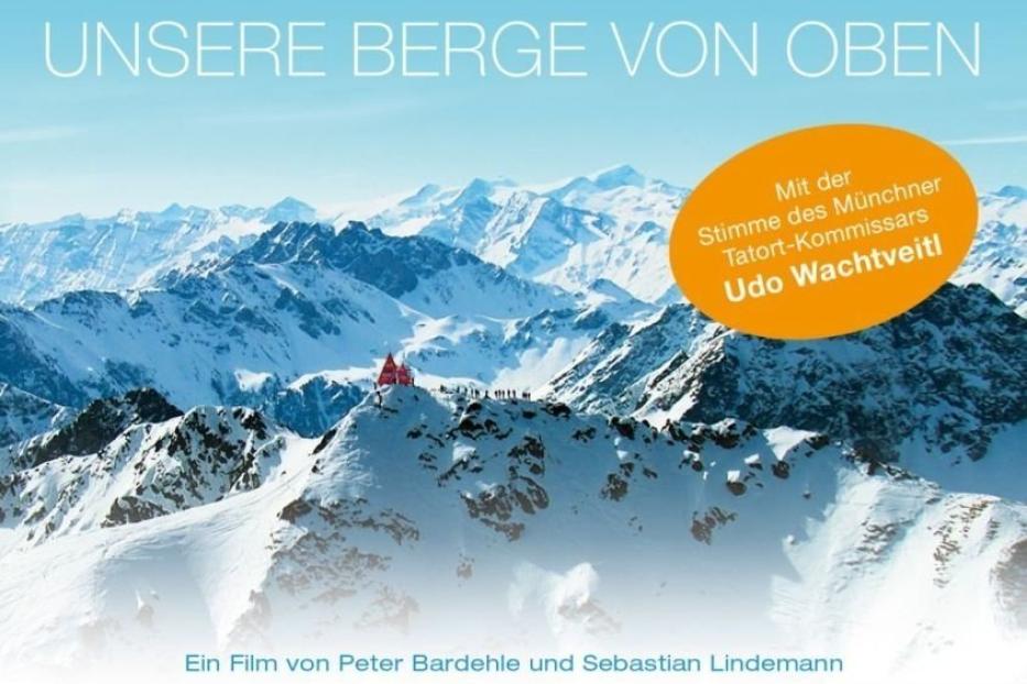 Das Filmplakat für „Die Alpen – Unsere Berge von oben“ zeigt schneebedeckte Berggipfel.