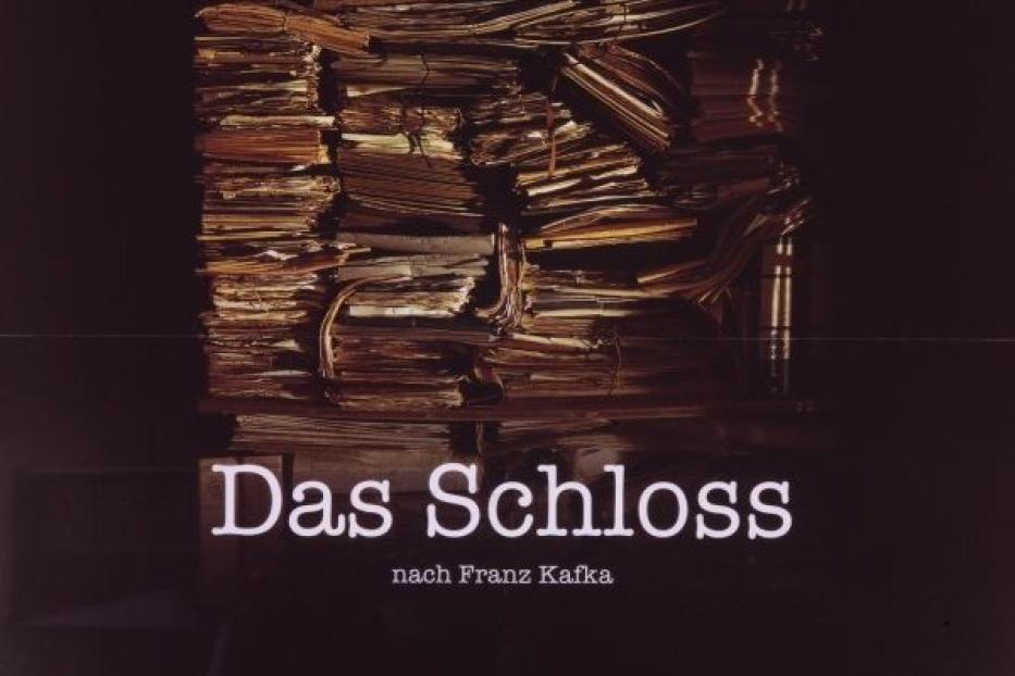 Das Filmplakat zu „Das Schloss“ nach Franz Kafka zeigt einen Stapel Papier.