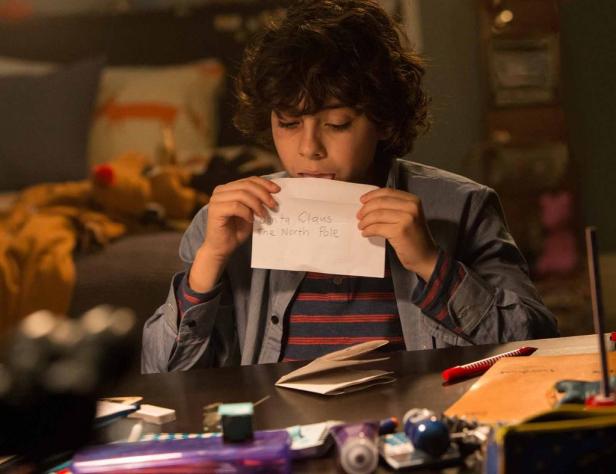 Ein Junge leckt an einem Brief an den Weihnachtsmann am Nordpol.