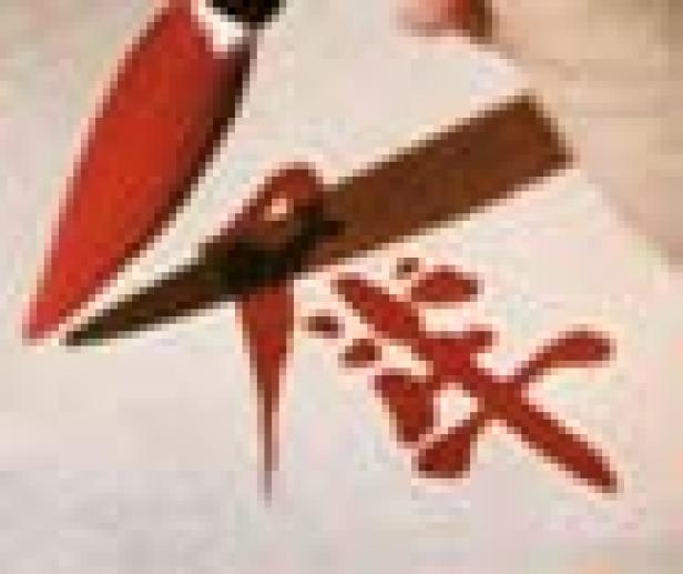 Ein roter Pinsel liegt auf einem Blatt Papier mit chinesischen Schriftzeichen.