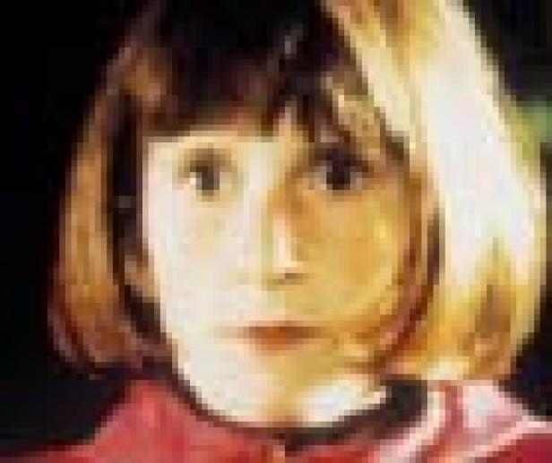 Nahaufnahme eines jungen Mädchens mit braunen Haaren und ernstem Blick.