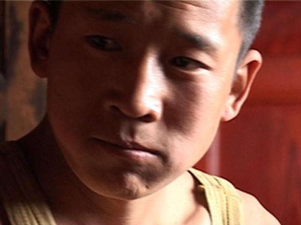 Ein junger Mann mit dunklen Haaren und einem ernsten Gesichtsausdruck.