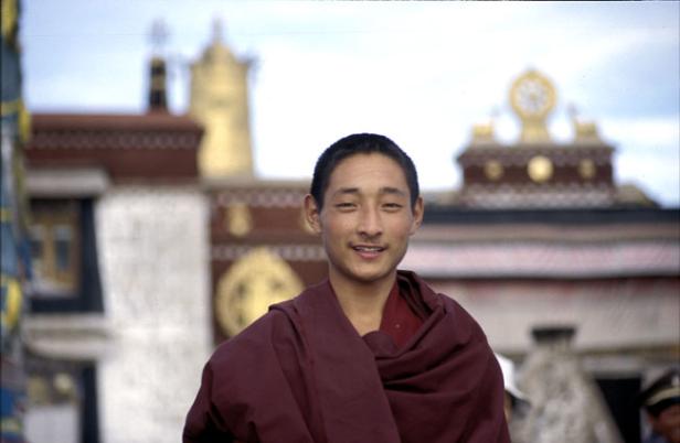 Ein junger buddhistischer Mönch vor einem Tempel in Tibet.