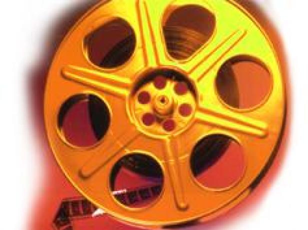 Eine goldene Filmrolle mit einem Stück Filmband.