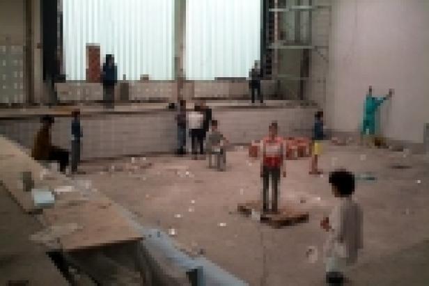 Eine Gruppe von Kindern spielt in einem unordentlichen Raum mit Bauschutt.