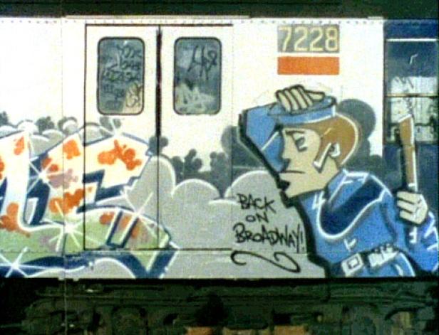Ein Zugwaggon ist mit Graffiti und einer Cartoonfigur bemalt.