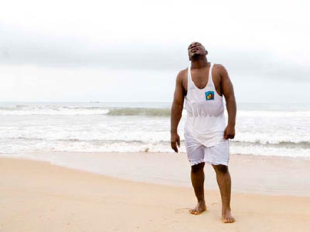 Ein Mann steht am Strand und blickt in den Himmel.