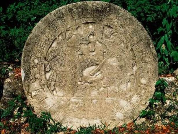 Ein runder, verzierter Stein mit alten Reliefs, möglicherweise ein Maya-Kalender.