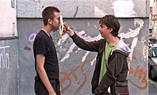 Ein Mann hält einem anderen eine Banane vors Gesicht.