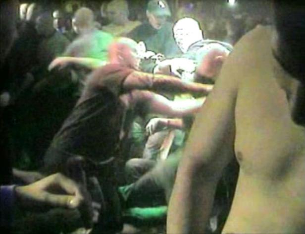 Eine Menschenmenge drängt sich in einem dunklen Raum.