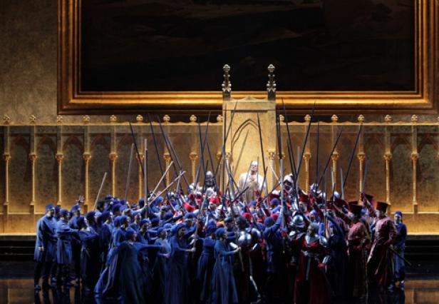 Eine Bühnenszene mit einer großen Gruppe von Darstellern in historischen Kostümen und Waffen.