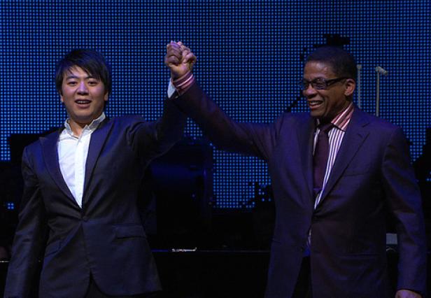 Lang Lang und Herbie Hancock stehen auf einer Bühne und halten Hände.