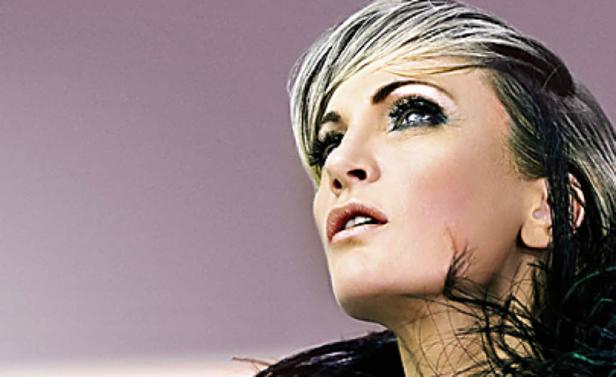 Porträt einer Frau mit blond gesträhnten Haaren, die nach oben blickt.