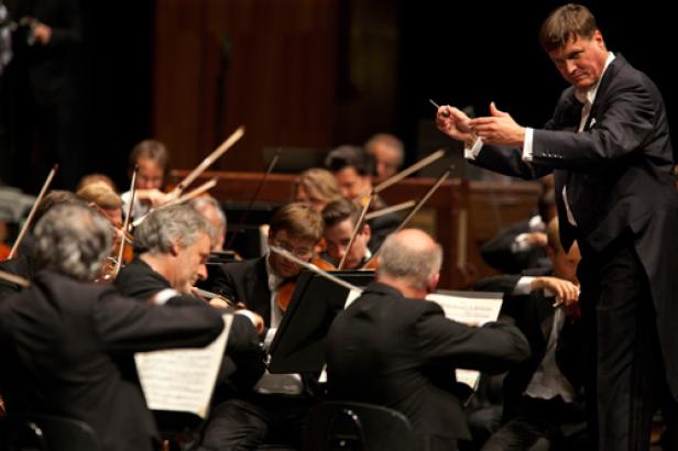 Ein Dirigent leitet ein Orchester während eines Konzerts.