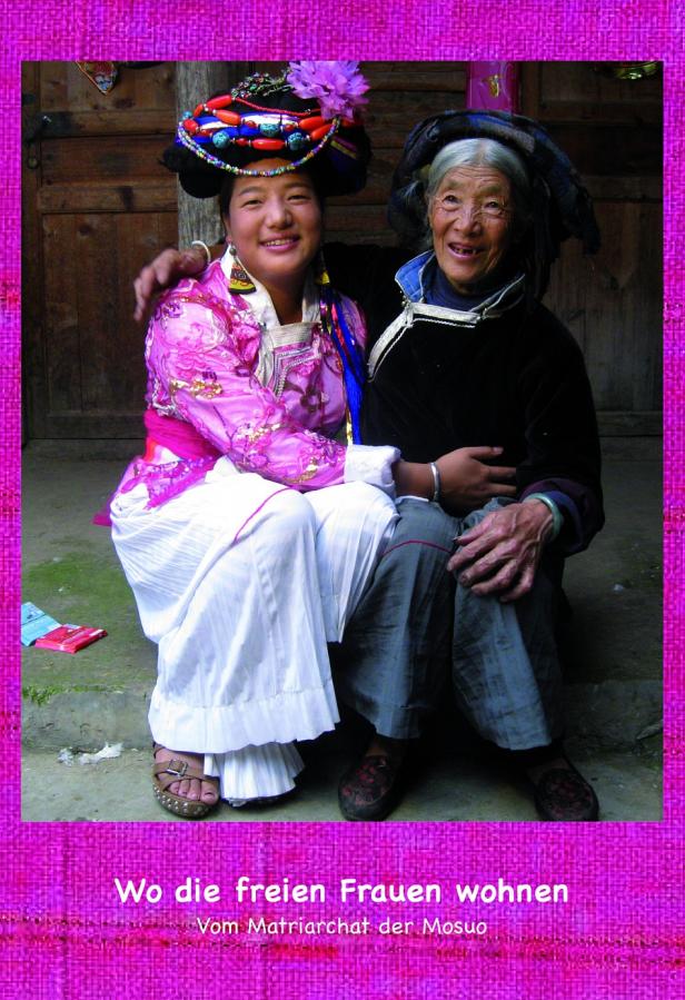 Zwei Mosuo-Frauen in traditioneller Kleidung posieren für ein Foto.