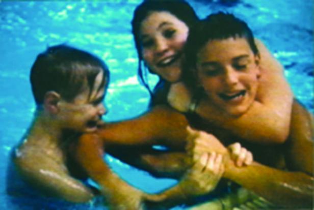 Drei Kinder haben Spaß im Schwimmbad.