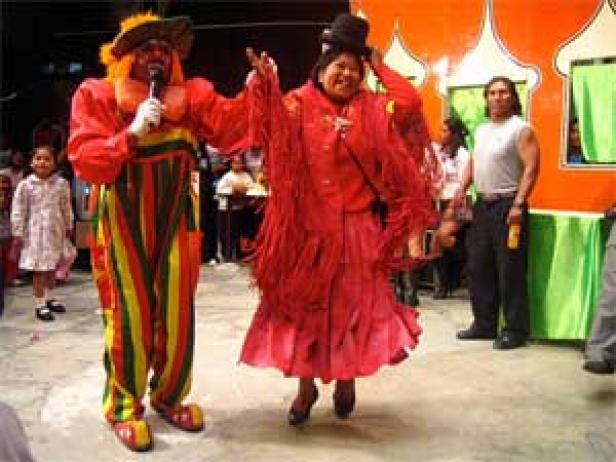 Zwei als Clowns verkleidete Personen treten vor einem Publikum auf.