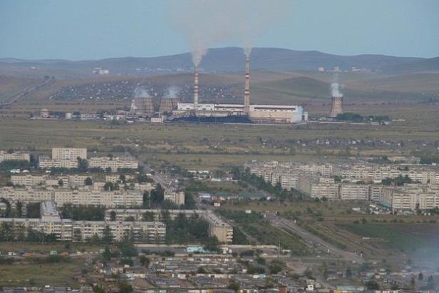 Blick auf eine Stadt mit einem Kraftwerk im Hintergrund.